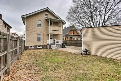 a house with a fence next to a yard at Lakewood Home with Yard about 8 Mi to Cleveland! in Lakewood