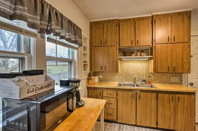 a kitchen with wooden cabinets and a sink at Lakewood Home with Yard about 8 Mi to Cleveland! in Lakewood