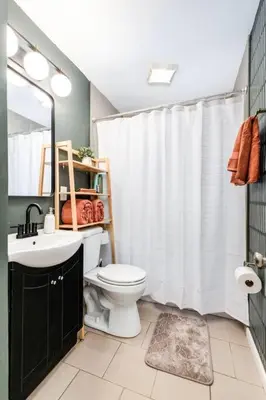 a bathroom with a white shower curtain and a toilet at City Boho ✦ New Kitchen ✦ King Bed ✦ WFH in Bexley