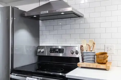 a kitchen with a stove with a rack of utensils at City Boho ✦ New Kitchen ✦ King Bed ✦ WFH in Bexley