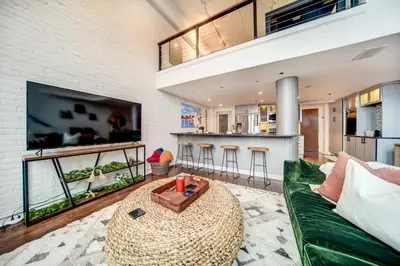 a living room with a green couch and a table at Waterfront Cleveland Apt about 1 Mi to Downtown in Cleveland