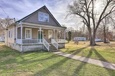 a small house with a porch and a tree at Manchester Getaway on Ohio River Scenic Byway in Manchester