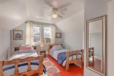 a bedroom with two beds and a mirror at Manchester Getaway on Ohio River Scenic Byway in Manchester