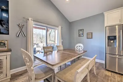 a dining room with a table and a refrigerator at Waterfront Home on Lake Milton Dock, Hot Tub in Lake Milton