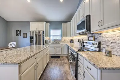 a kitchen with white cabinets and granite counter tops at Waterfront Home on Lake Milton Dock, Hot Tub in Lake Milton
