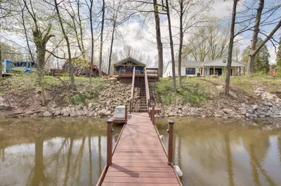 a wooden bridge over a river with a house at Waterfront Home on Lake Milton Dock, Hot Tub in Lake Milton