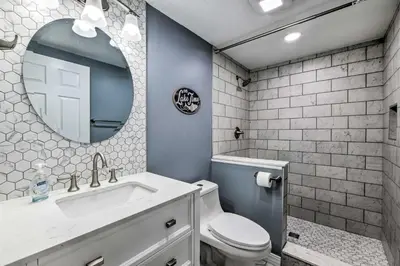 a bathroom with a sink and a toilet and a mirror at Waterfront Home on Lake Milton Dock, Hot Tub in Lake Milton