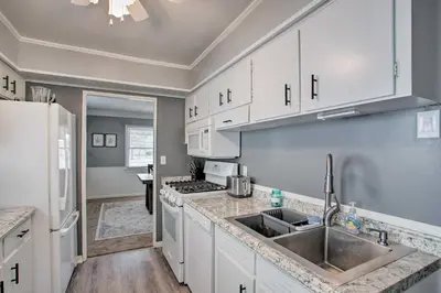 a kitchen with white cabinets and a sink at Peaceful Cottage about 8 Mi to Downtown Toledo! in Toledo