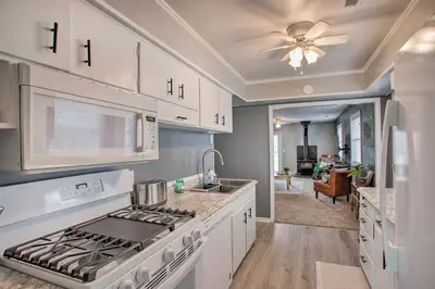 a kitchen with white cabinets and a stove top oven at Peaceful Cottage about 8 Mi to Downtown Toledo! in Toledo