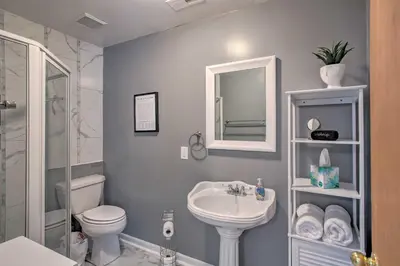 a bathroom with a sink and a toilet and a mirror at Peaceful Cottage about 8 Mi to Downtown Toledo! in Toledo