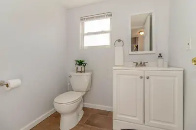 a white bathroom with a toilet and a sink at Downtown Views-Prime Location! in Cincinnati