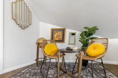 a room with two chairs and a table with yellow pillows at Downtown Views-Prime Location! in Cincinnati