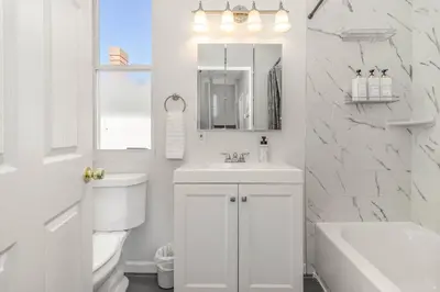 a white bathroom with a sink and a mirror at Downtown Views-Prime Location! in Cincinnati