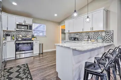 a kitchen with white cabinets and a counter with chairs at German Village Getaway with Grill 4 Mi to OSU! in Columbus