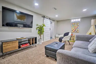 a living room with a couch and a large flat screen tv at German Village Getaway with Grill 4 Mi to OSU! in Columbus