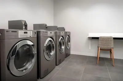 three washing machines in a laundry room with a chair at TownePlace Suites by Marriott Cincinnati Mason in Mason