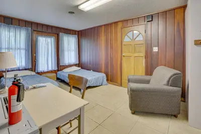 a room with a bedroom with a bed and a chair at Pet-Friendly Youngstown Cottage with Yard in Youngstown