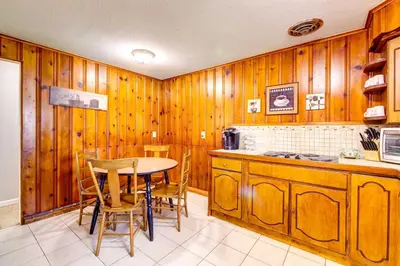 a kitchen with wooden walls and a table and chairs at Pet-Friendly Youngstown Cottage with Yard in Youngstown