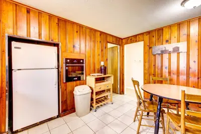 a kitchen with a table and a white refrigerator at Pet-Friendly Youngstown Cottage with Yard in Youngstown