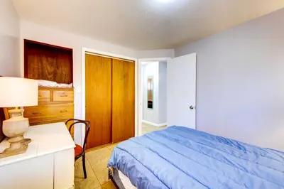 a bedroom with a bed and a desk with a lamp at Pet-Friendly Youngstown Cottage with Yard in Youngstown