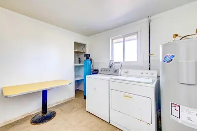 a kitchen with a washer and a refrigerator at Pet-Friendly Youngstown Cottage with Yard in Youngstown