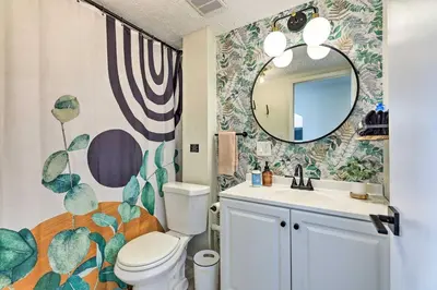 a bathroom with a toilet and a sink and a mirror at Cincinnati Vacation Rental 6 Mi to Downtown! in Cincinnati