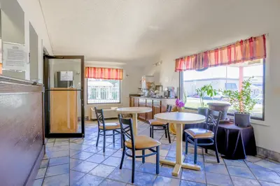 a kitchen with two tables and chairs in a room at Cozy Garden Inn By OYO Hwy 40 Richmond in Richmond