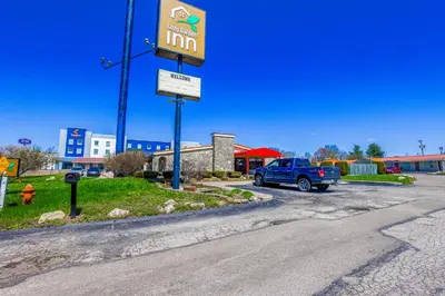 a sign in a parking lot with a blue truck at Cozy Garden Inn By OYO Hwy 40 Richmond in Richmond
