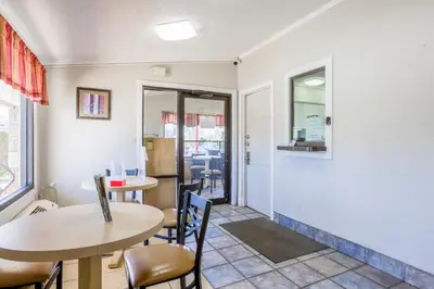 a dining room with two tables and chairs at Cozy Garden Inn By OYO Hwy 40 Richmond in Richmond