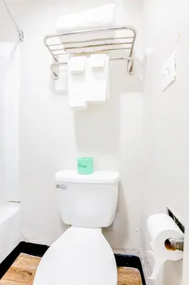 a bathroom with a white toilet and toilet paper at Cozy Garden Inn By OYO Hwy 40 Richmond in Richmond
