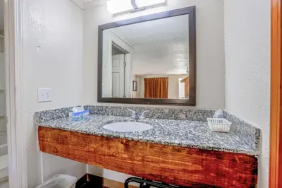 a bathroom with a sink and a mirror at Cozy Garden Inn By OYO Hwy 40 Richmond in Richmond