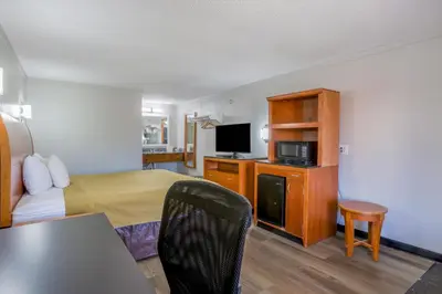 a hotel room with a bed and a tv at Cozy Garden Inn By OYO Hwy 40 Richmond in Richmond