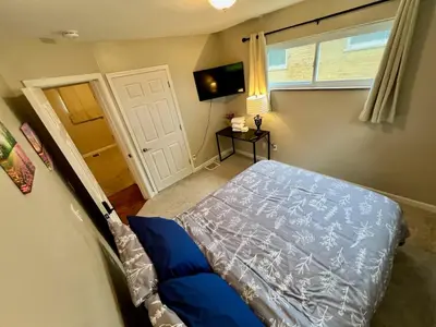 a bedroom with a bed and a window and a door at Sunny Stay Bright and Cozy Suite 1 in Cincinnati