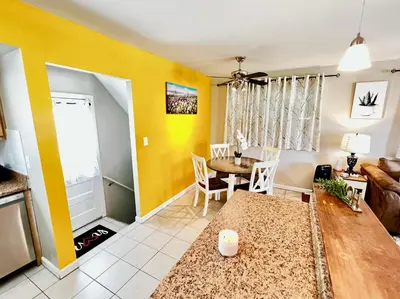 a living room with yellow walls and a table at Sunny Stay Bright and Cozy Suite 1 in Cincinnati
