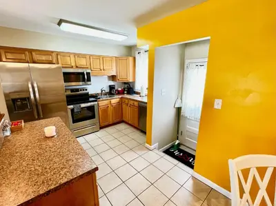a kitchen with yellow walls and wooden cabinets at Sunny Stay Bright and Cozy Suite 1 in Cincinnati