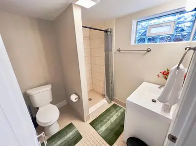 a bathroom with a shower and a toilet and a sink at Sunny Stay Bright and Cozy Suite 1 in Cincinnati