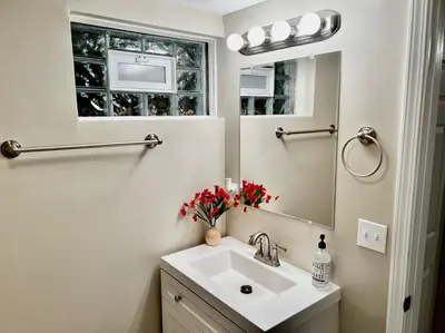 a white bathroom with a sink and a mirror at Sunny Stay Bright and Cozy Suite 1 in Cincinnati