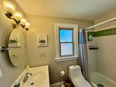 a bathroom with a sink and a toilet and a mirror at Cozy Bungalow Quiet Neighborhood Suite 1 in Cincinnati