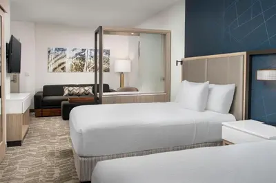 a hotel room with two beds and a living room at SpringHill Suites by Marriott Cincinnati Mason in Mason