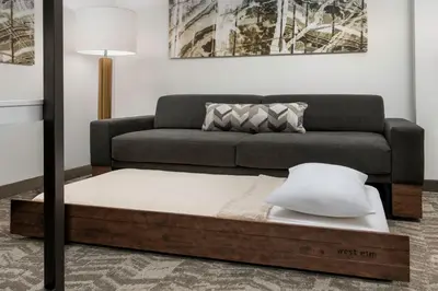 a bed in a living room with a couch at SpringHill Suites by Marriott Cincinnati Mason in Mason