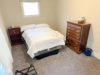 a bedroom with a bed and a wooden dresser at IvyLand Pines in Cleveland Heights