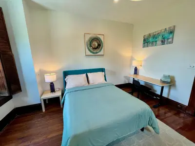 a bedroom with a bed and a desk with two lamps at Skyline Retreat Spacious Elegance Queen Suite 2 City Views in Cincinnati