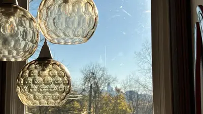 a view of a window with a pineapple chandelier at Skyline Retreat Spacious Elegance Queen Suite 2 City Views in Cincinnati