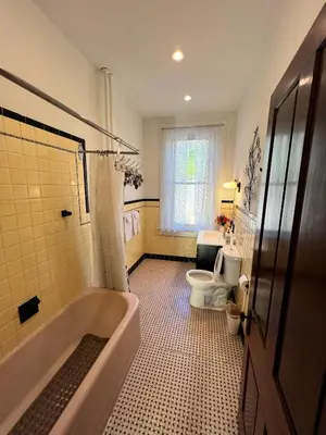 a bathroom with a tub and a toilet at Skyline Retreat Spacious Elegance Queen Suite 2 City Views in Cincinnati