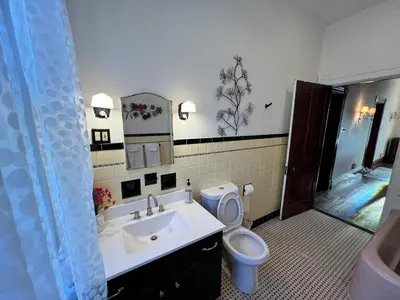 a bathroom with a sink and a toilet and a mirror at Skyline Retreat Spacious Elegance Queen Suite 2 City Views in Cincinnati