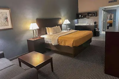a hotel room with a bed and a couch at Suburban Studios Montpelier in Montpelier