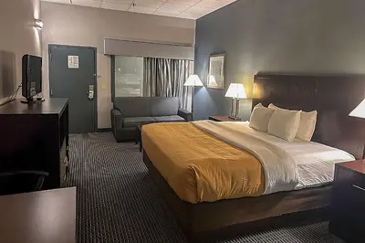 a hotel room with a bed and a chair at Suburban Studios Montpelier in Montpelier