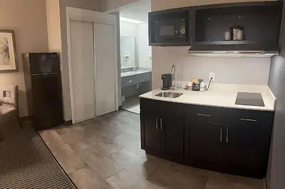 a kitchen with a sink and a black refrigerator at Suburban Studios Montpelier in Montpelier