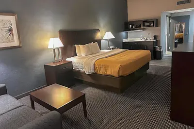 a hotel room with a bed and a couch at Suburban Studios Montpelier in Montpelier
