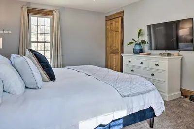 a bedroom with a white bed and a television at Gambier Vacation Rental about 5 Mi to Mt Vernon! in Gambier